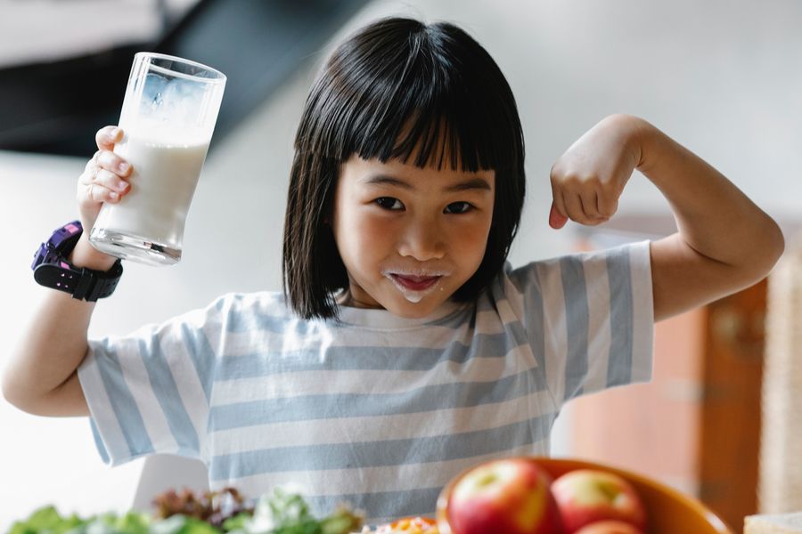 Deklica pije mleko za močne kosti